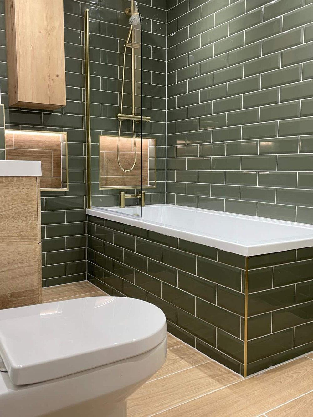 Green metro tiles with an oak lined, lit niche