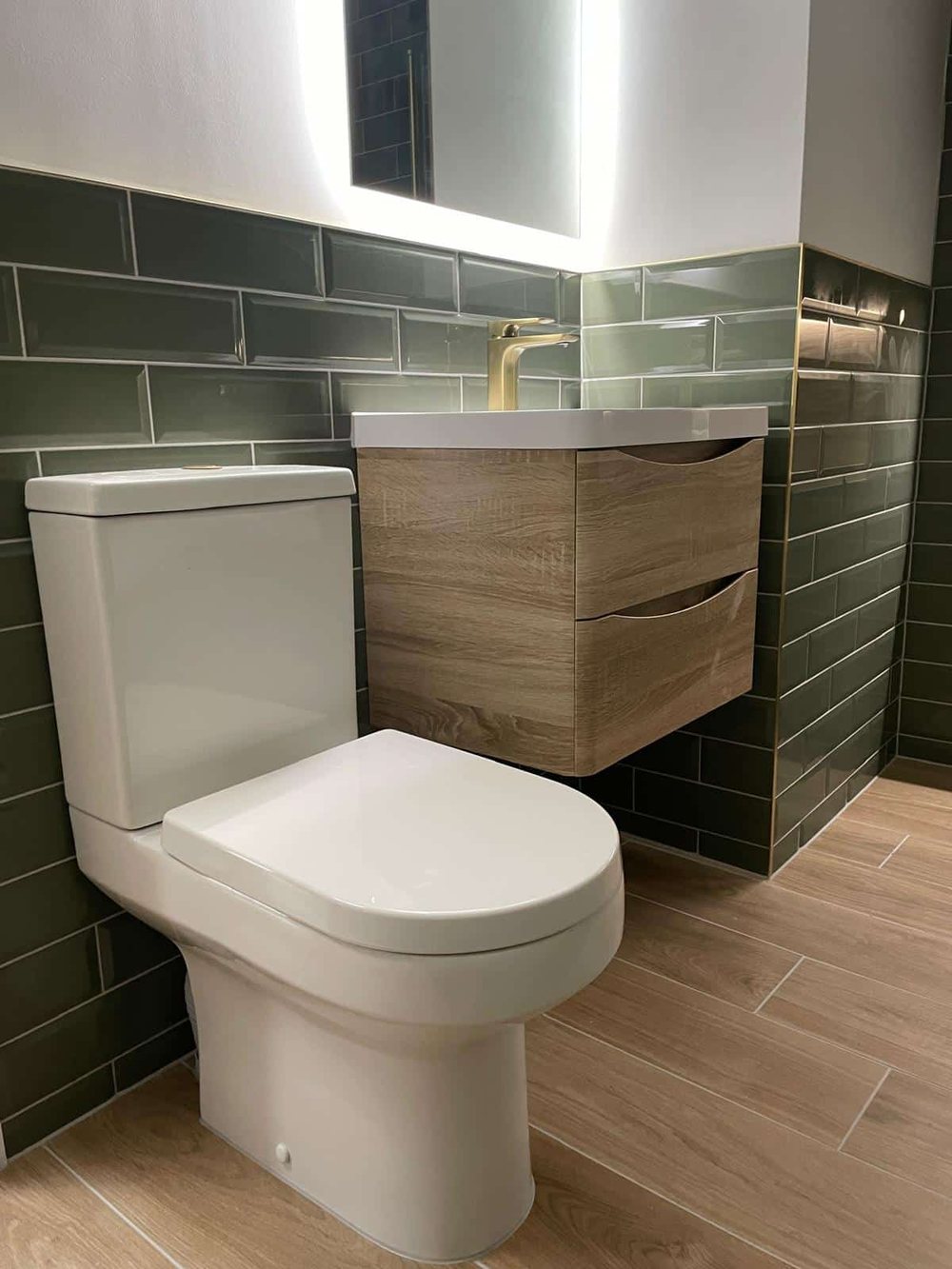Oak vanity unit against green metro tiles