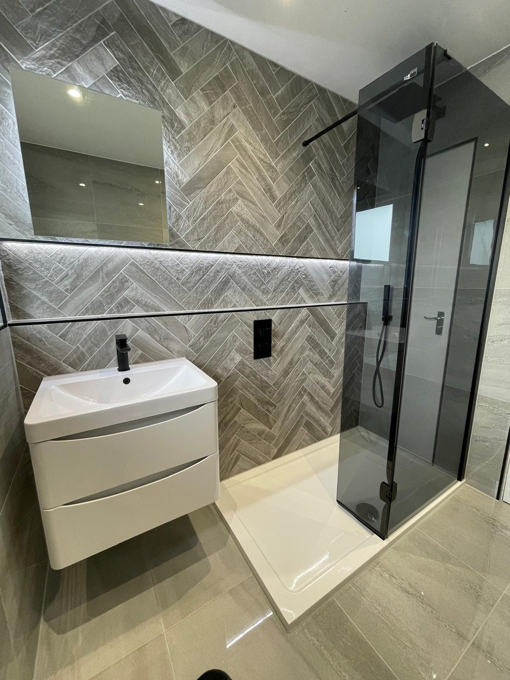 Herringbone tiled shower with a glass screen