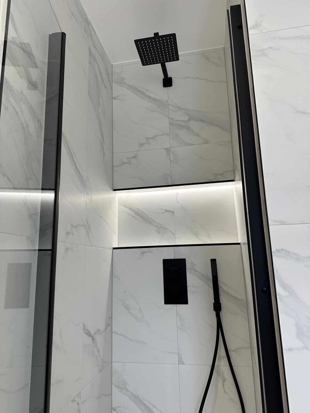 Marble effect shower with an LED lit shelf