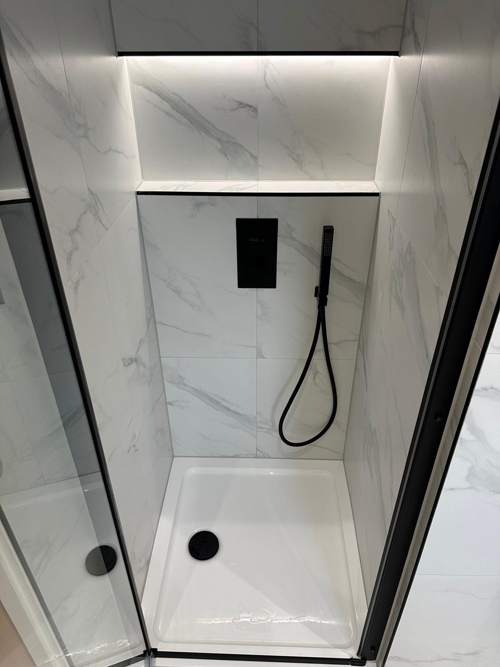Marble effect shower with a black hand shower