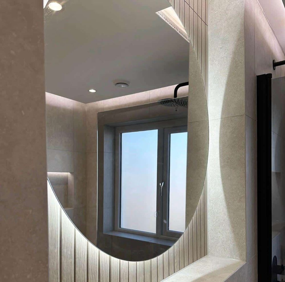 Round LED mirror reflecting a shower and window