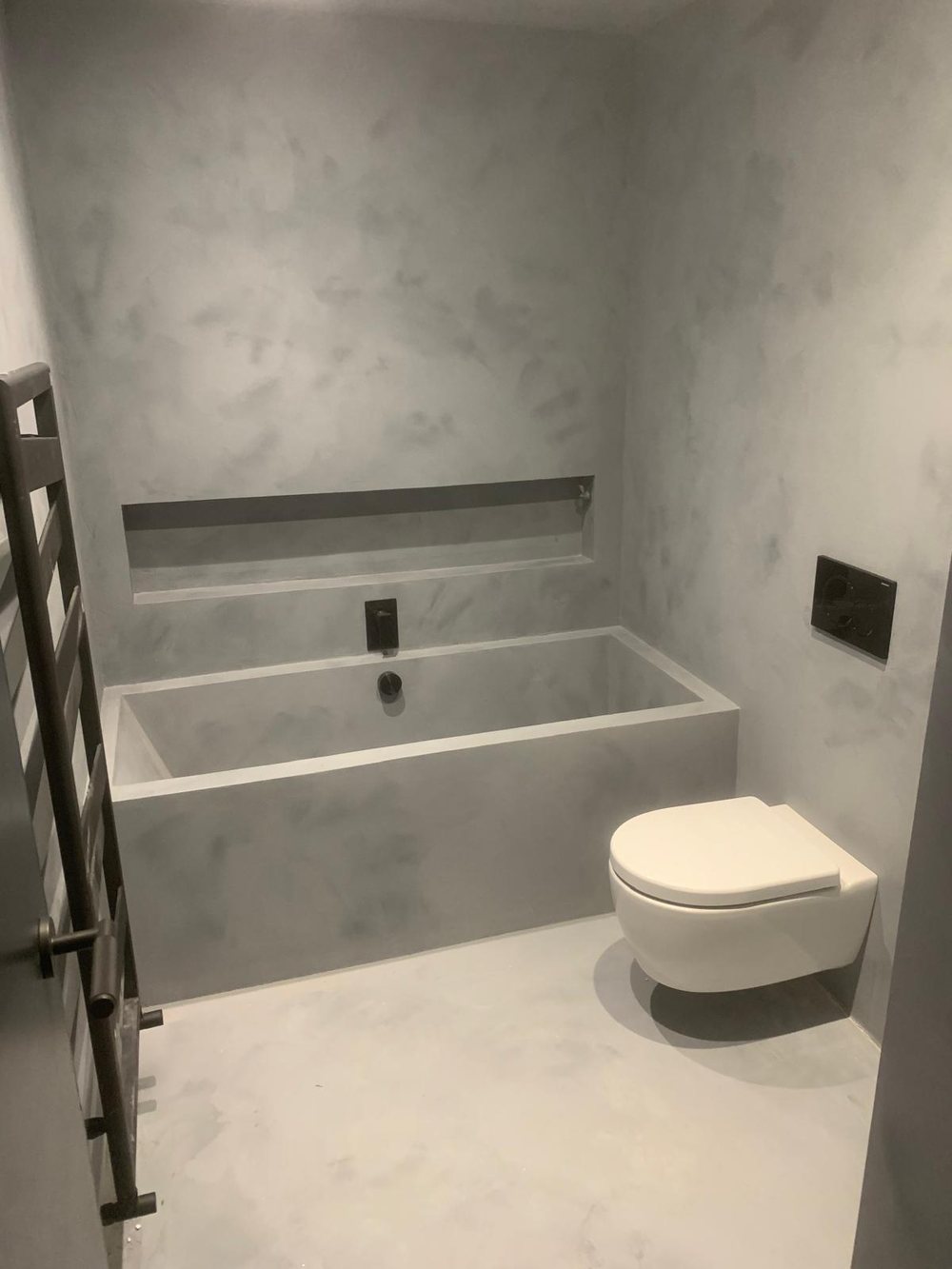 Stone effect bath surround with a long niche